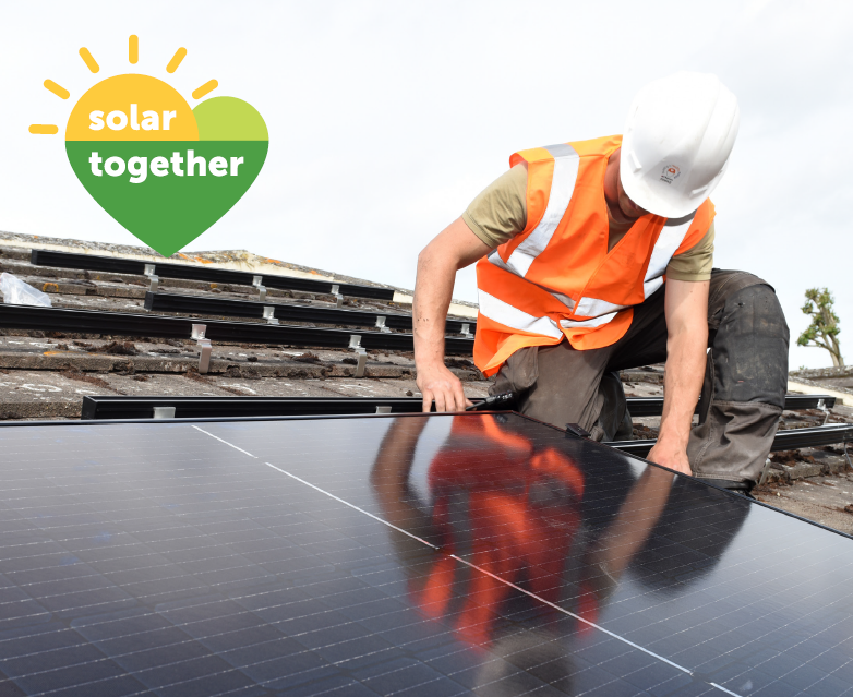 Man in high vis on roof installing a solar panel