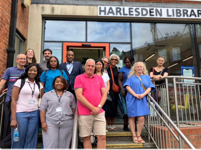 14 people standing on the steps outside Harlesden Library