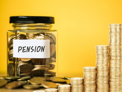 A jar full of coins which says 'pension' and stacked coins on a yellow background