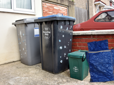 Rubbish and recycling bins and a sack