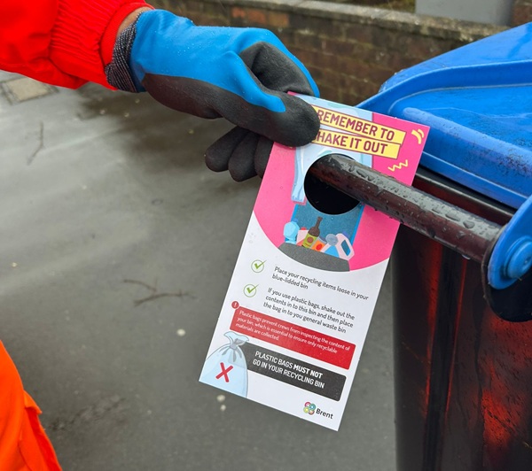 Man putting a bin hanger onto a recycling bin