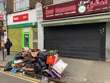 Dumped rubbish piled up on street in front of shop