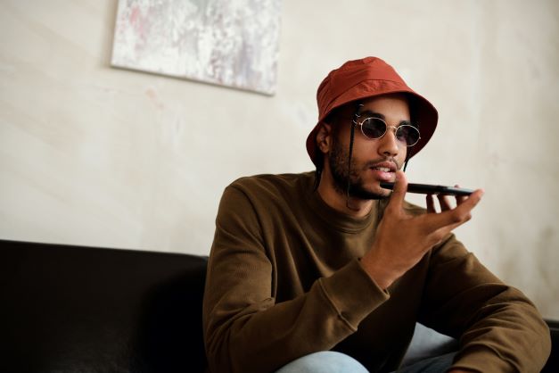 A man sitting on the sofa speaking into a mobile phone