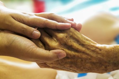 carer holding elderly persons hand