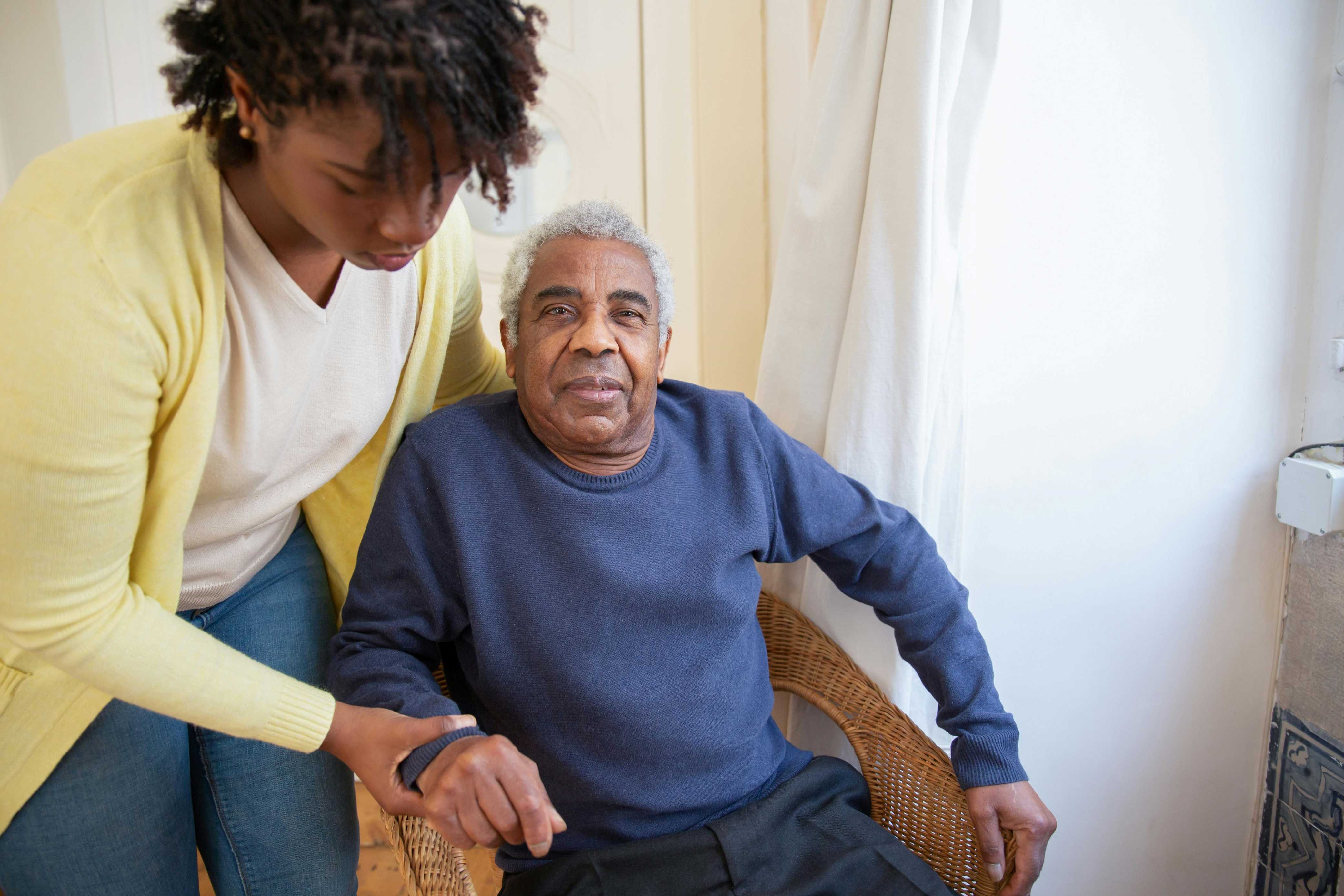 A woman helping an older man into his seat