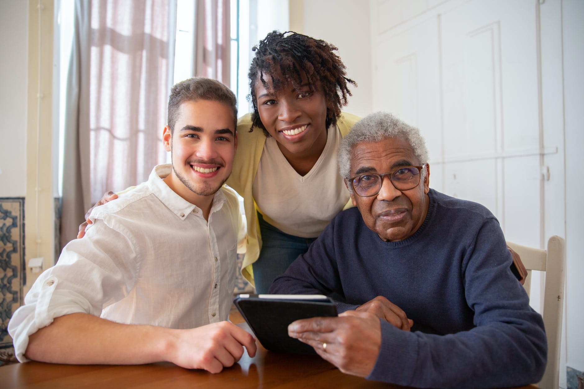 Older man sitting with a young woman and man