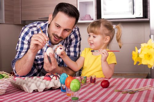 dad and daughter painting eggs