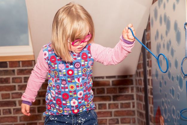 Toddler with Downs Syndrome playing with bubbles