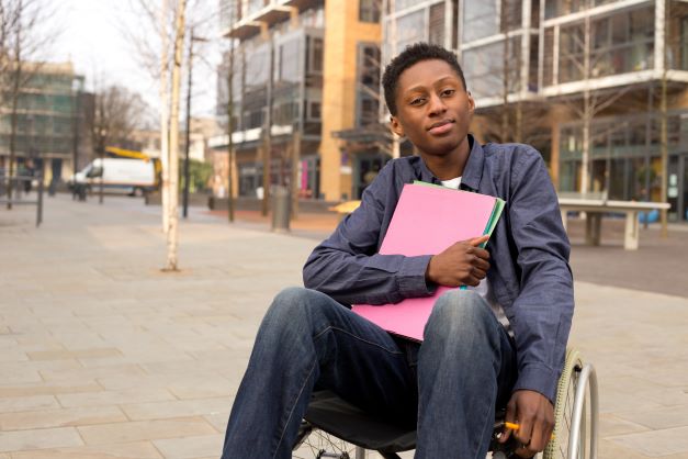 Young boy in a wheelchair outside school