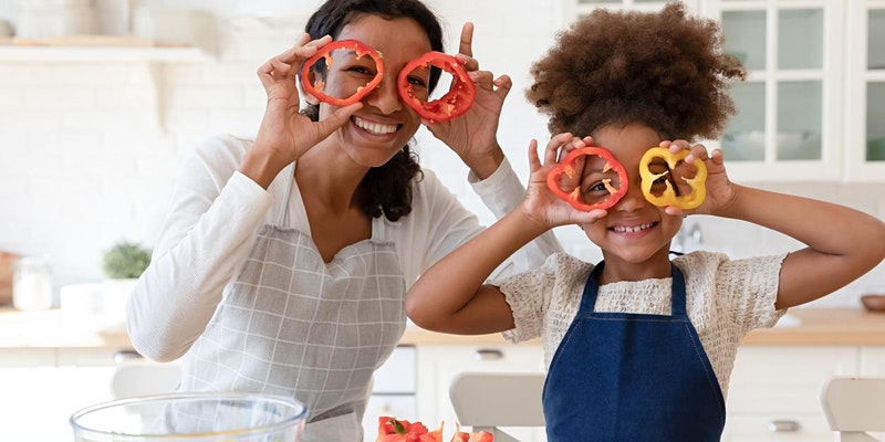 Parent and their child cooking together with peppers over their eyes