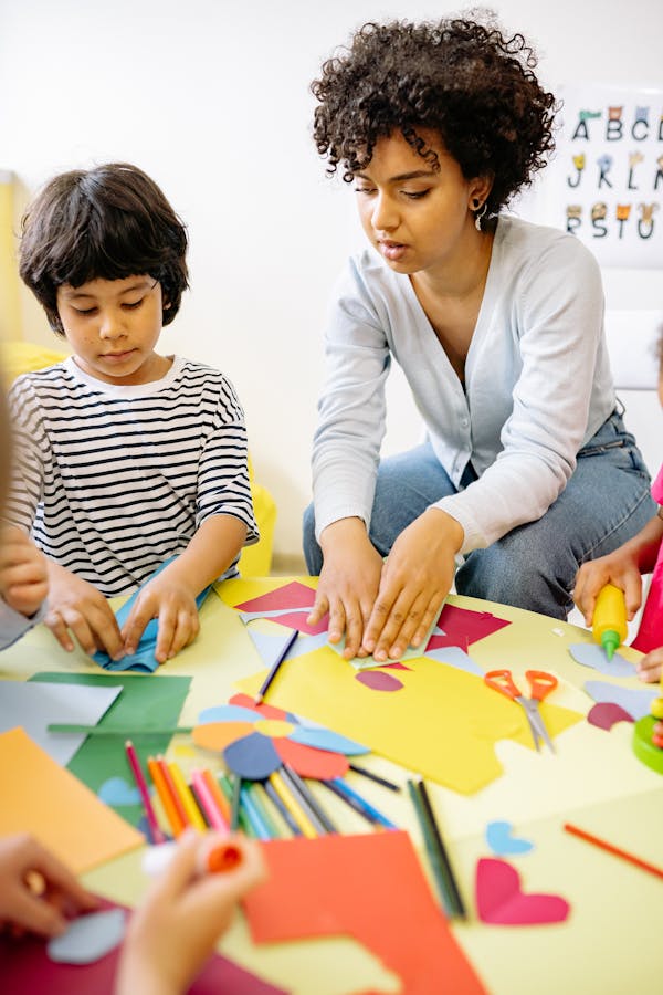 Child at a nursery playing at a table with an early years teacher