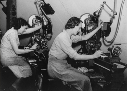 black and white photo of two women sitting by sewing machines